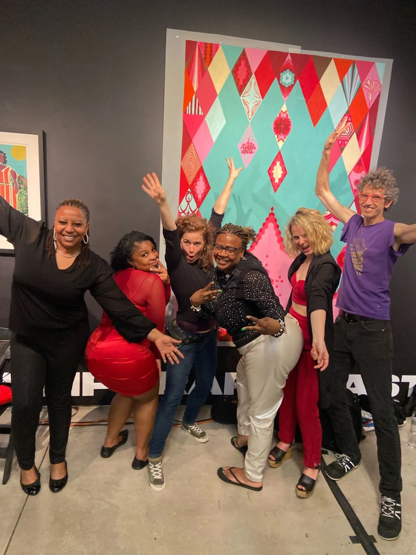 Ronna celebrating with supporters and donors in front of colorful artwork