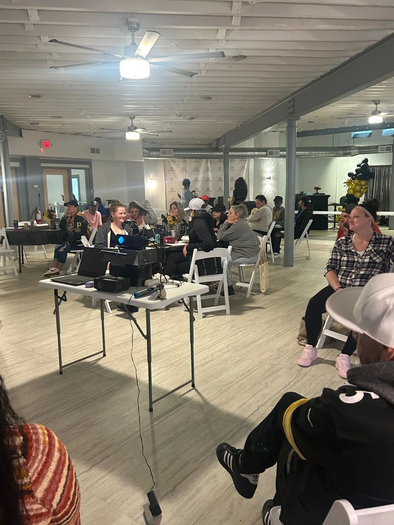 Community members gathered around tables for a workshop in The Sanctuary social hall